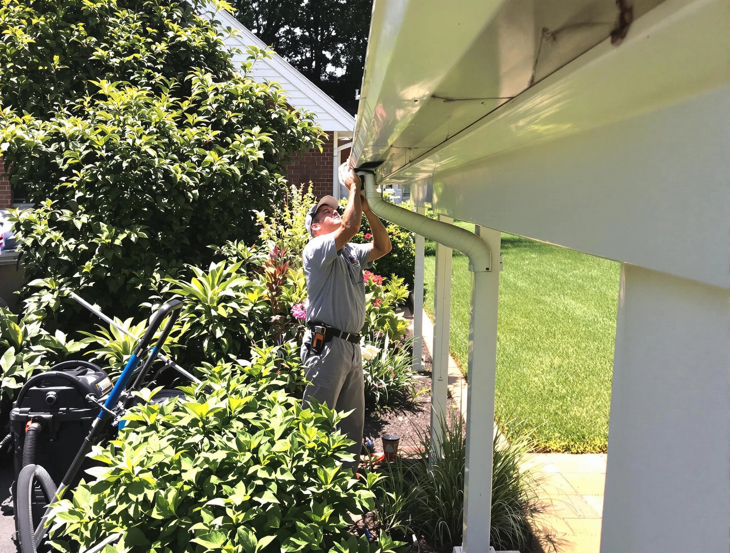 Technician flushing a blockage from a downspout in Solon, OH